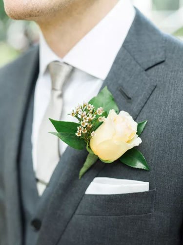 boutonniere-ivoire-jardin-rose-contre-costume-gris