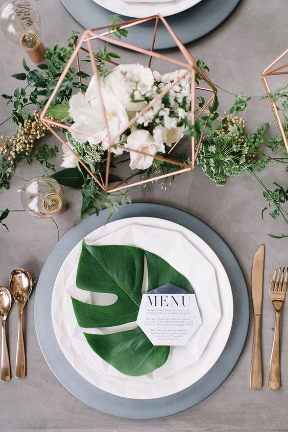 Centre de table en métal de cuivre avec des fleurs fraîches et une verdure