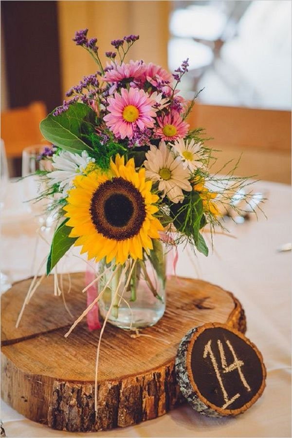 idees centre de table champetre pot en verre fleuri sur rondin en bois rustique, accompagné de numéro de table diy sur petit rondin en bois